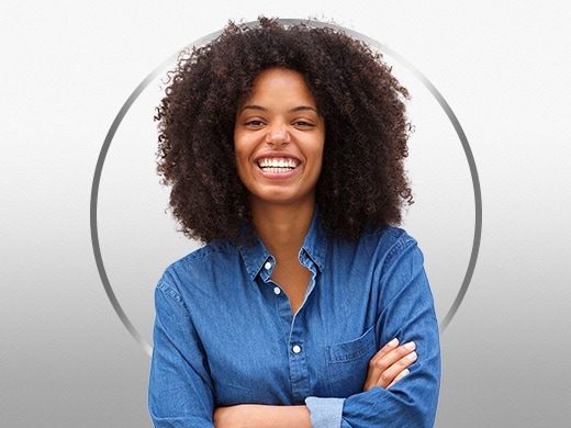 Smiling young woman with curly hair, wearing a blue shirt, happy after Canesten thrush treatment